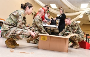 Offutt Air Force Base personnel load completed gift bags into boxes at the Bellevue Volunteer Fire Department on Dec. 11, 2024. Operation Holiday Cheer brought over 40 local community leaders and Offutt Airmen together to pack 480 gift bags for dormitory residents. (U.S. Air Force photo by Chad Watkins)