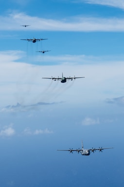 A formation of C-130J Super Hercules and C-130H Hercules aircraft fly together over the Pacific Ocean, Dec. 14, 2024, to culminate Operation Christmas Drop 2024.