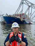 ASOFR LT Michael Gonzalez conducting daily rounds with the MV Dali in the background. The team went from barge to barge building rapport with the multiple contractors and oversaw safety for the entire operation as the Federal On-Scene Coordinator.