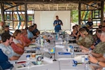 240916-N-ML137-1096 PELELIU, Republic of Palau (Sept. 16, 2024) - U.S. Coast Guard Lt. Cmdr. Derek Wallin, marine advisor with U.S. Coast Guard Forces Micronesia/Sector Guam, gives a presentation during the biannual, bilateral Joint Committee Meeting at South Dock Summerhouse, Sept. 16. JCMs are aligned with the Compact of Free Association Title III: Security and Defense Relations, enabling ongoing dialogue between nations to enhance security and defense responsibilities in the region. This meeting underscores the mutual commitment to national security, international partnership, and environmental stewardship in the Pacific. (U.S. Navy photo by Mass Communication Specialist 1st Class Samantha Jetzer)