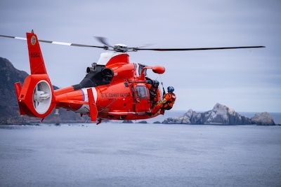 A Coast Guard Air Station San Francisco MH-65 Dolphin helicopter conducts cliff hoisting evolutions in Pacifica, Calif., Sept. 10, 2024. Cliff rescue training allows crews to simulate rescues in difficult terrain, safely.