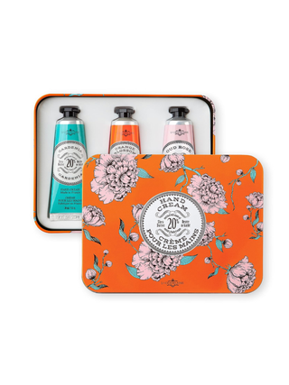 Three hand creams in a floral gift tin on a white background