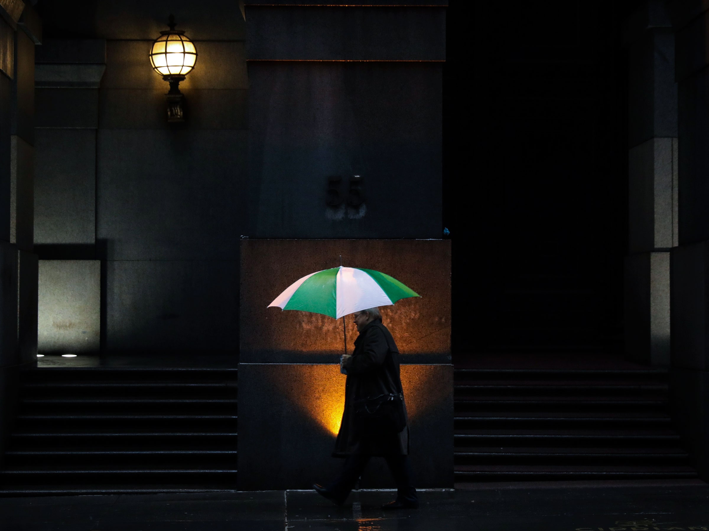 person with umbrella walking at night.