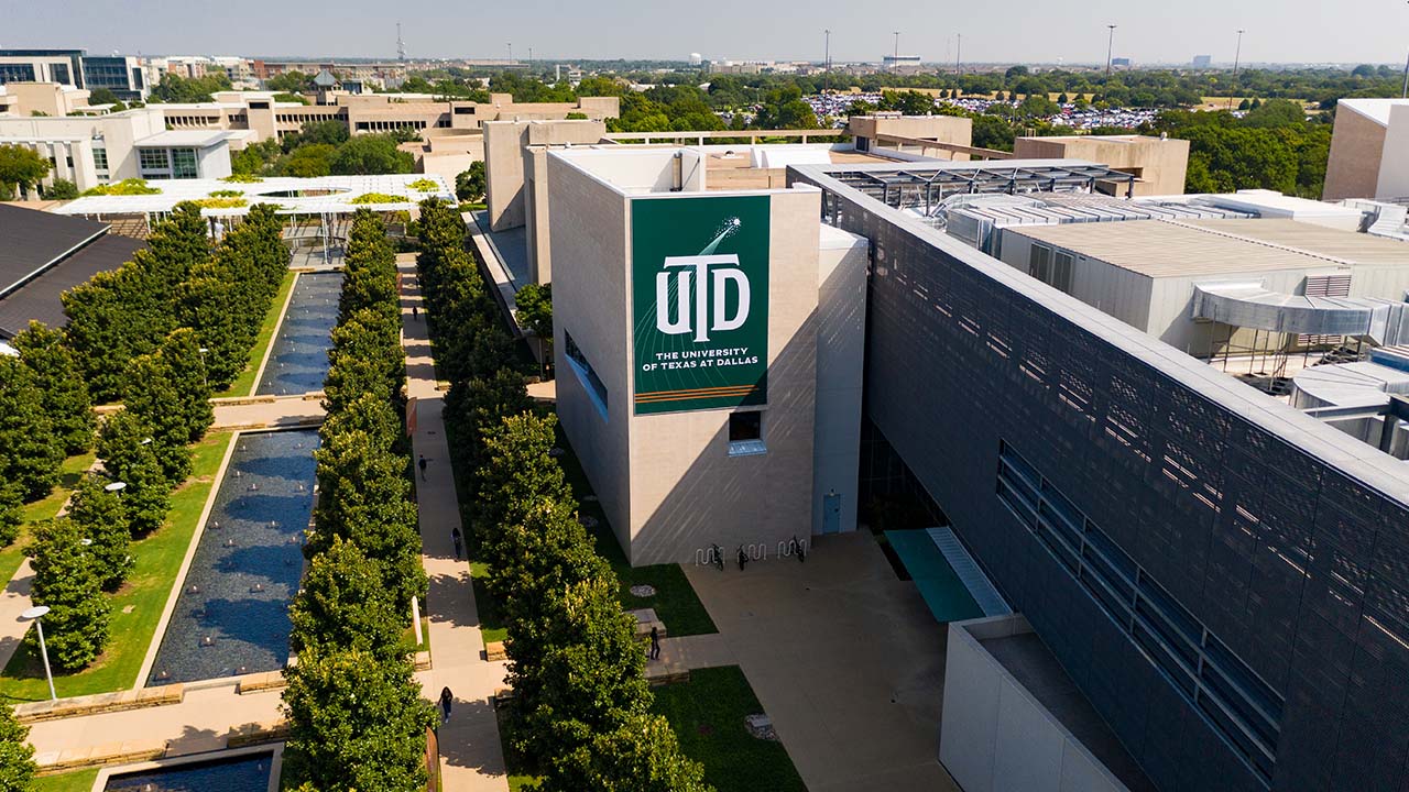 Image of UTD mall. Magnolia trees line a large outdoor area with fountains in the center.