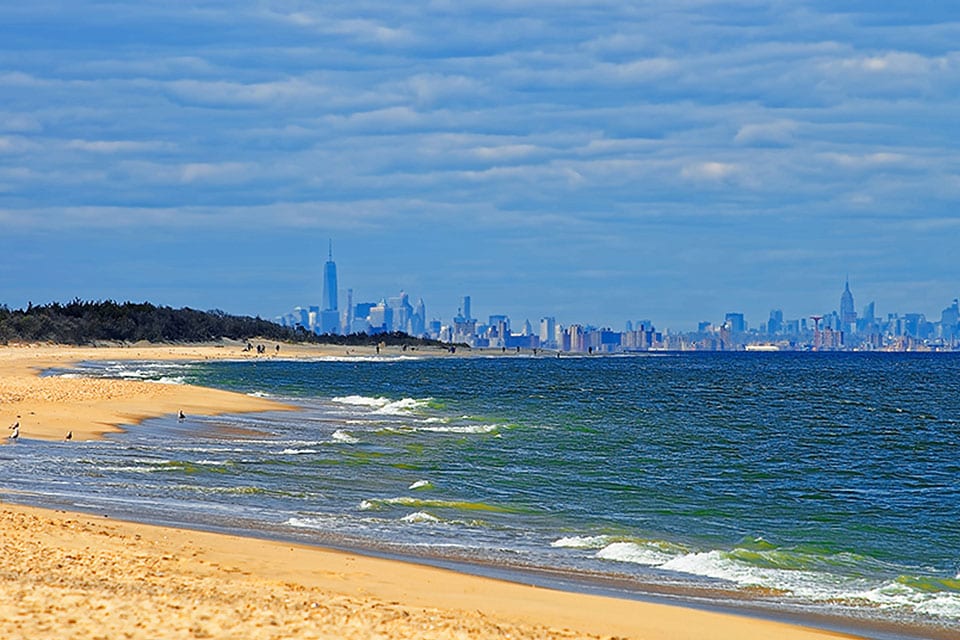 A New Jersey beach with a view of the New York City skyline.