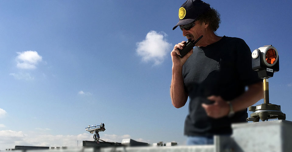 NOAA geodesist Roy Anderson sets up a retro-reflector, or prism, on the roof of a laboratory at the National Institute of Standards and Technology in Boulder, Colorado.