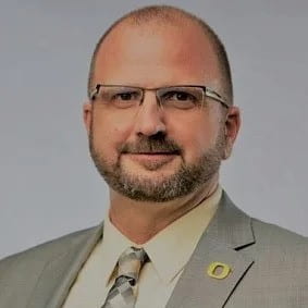 A headshot of a man smiling