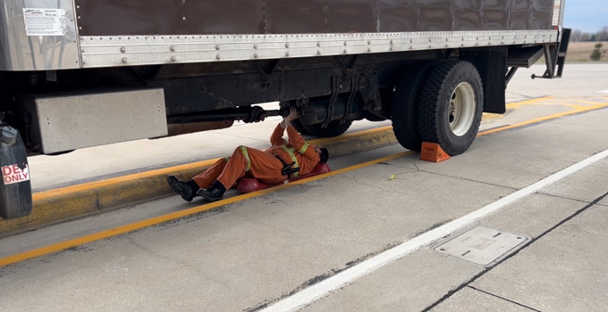 man under truck repairing it