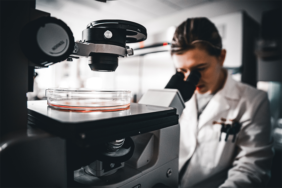 A woman looking into a microscope.