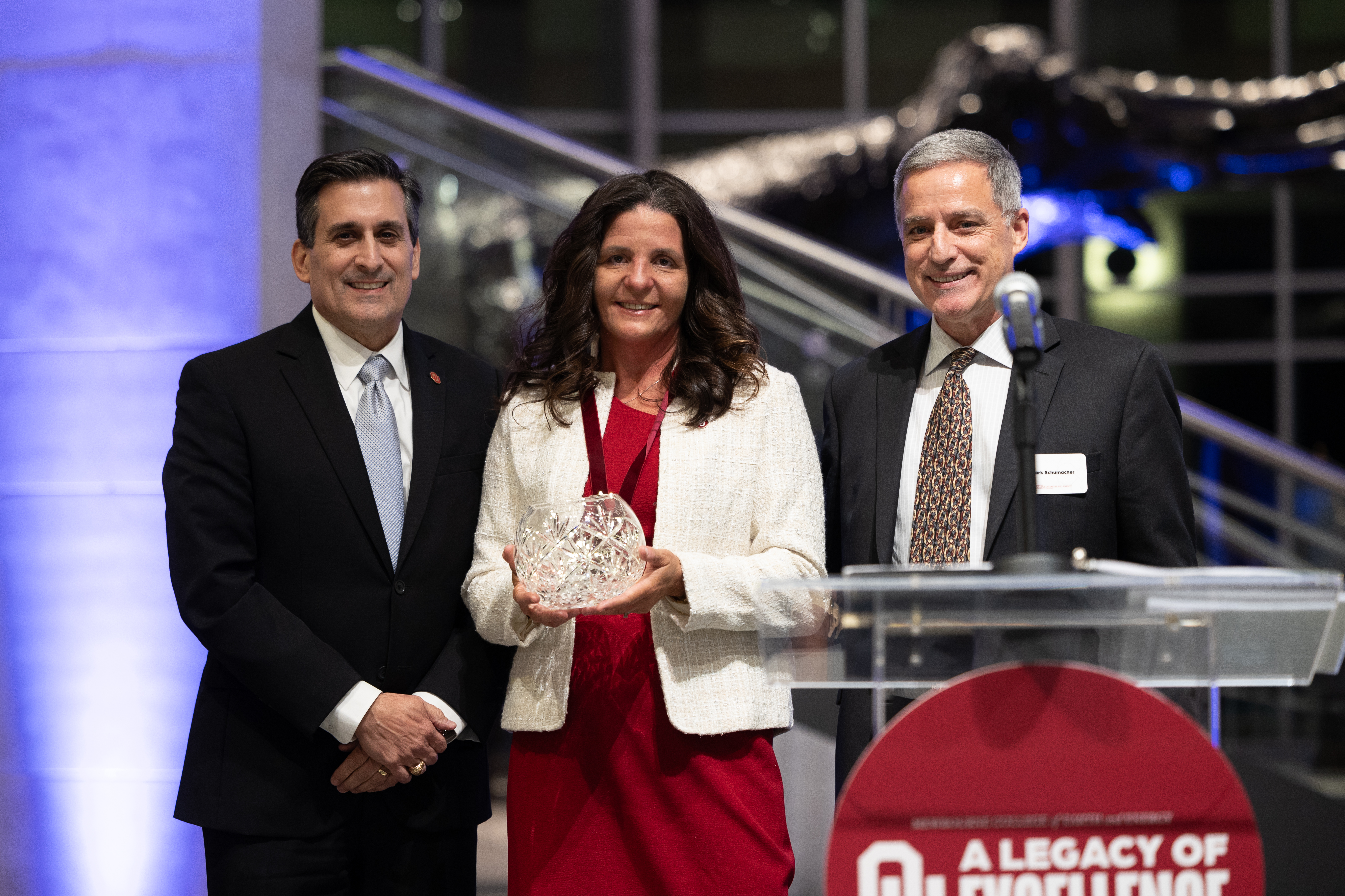 John Antonio, Nicole Baird and Mark Schumacher standing together after Baird received her award.