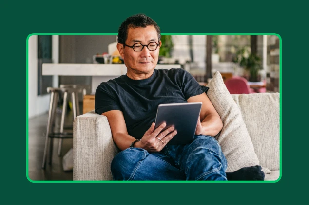 Man sitting in chair using tablet.