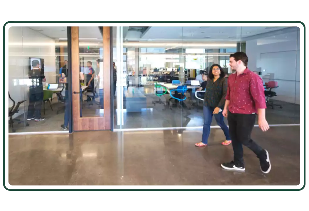 Two employees walking down an office hallway