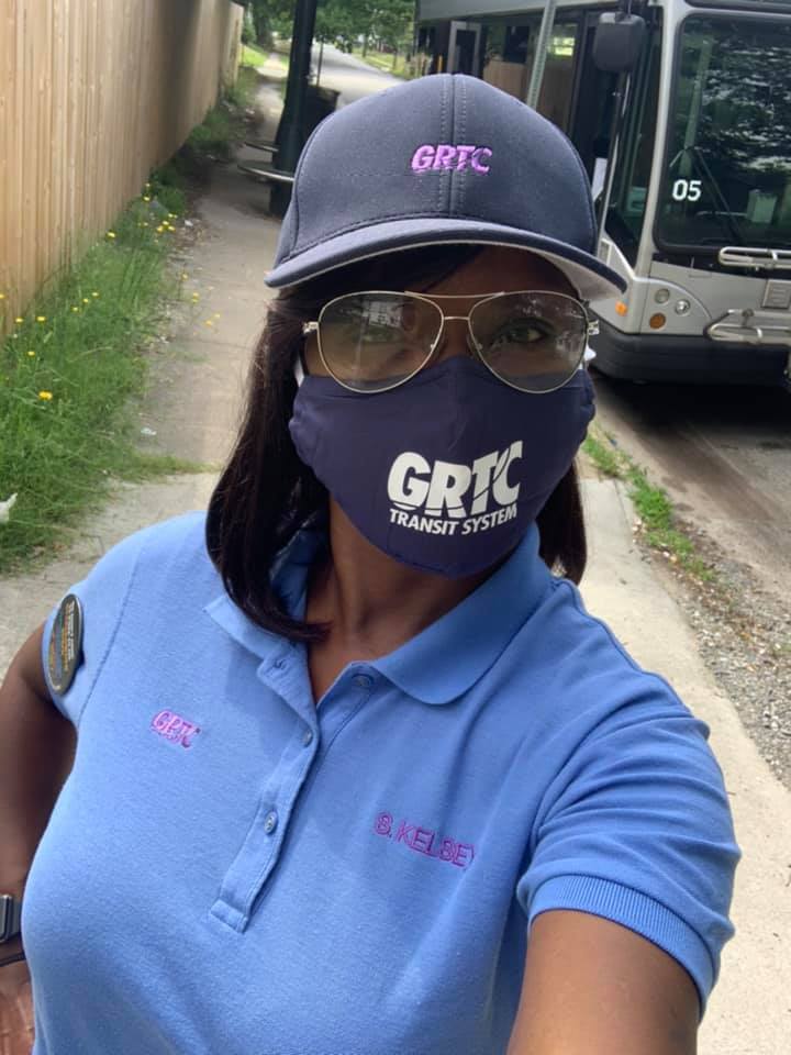 Operator wearing GRTC uniform face mask beside their bus