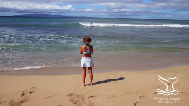 women on the beach looking at the ocean