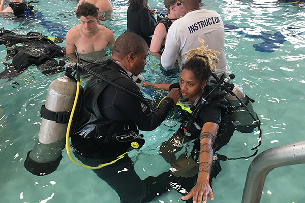 Scuba instructors teaching students in a pool