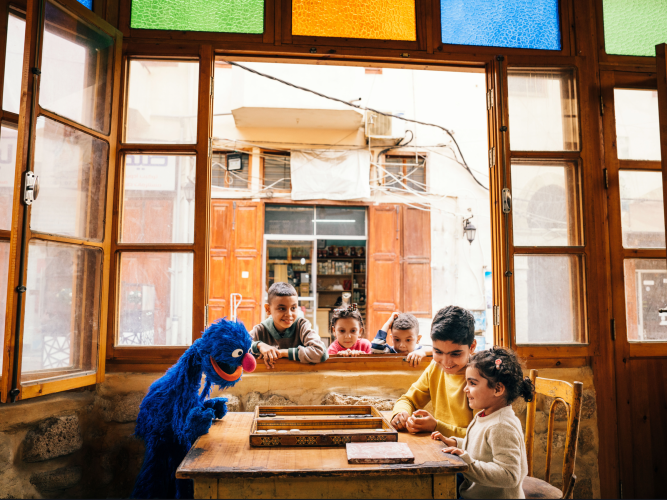 Grover at a table with two kids.