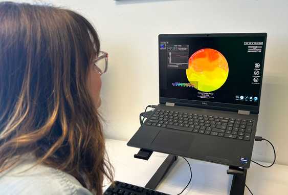 A person sits at a desk looking at a dataset of carbon dioxide 
    concentrations in SOS Explorer on a laptop computer screen.