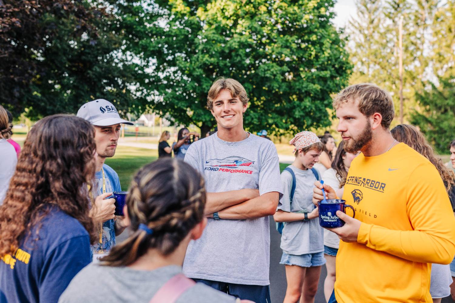 Group of students outside smiling at a student event happening at night.