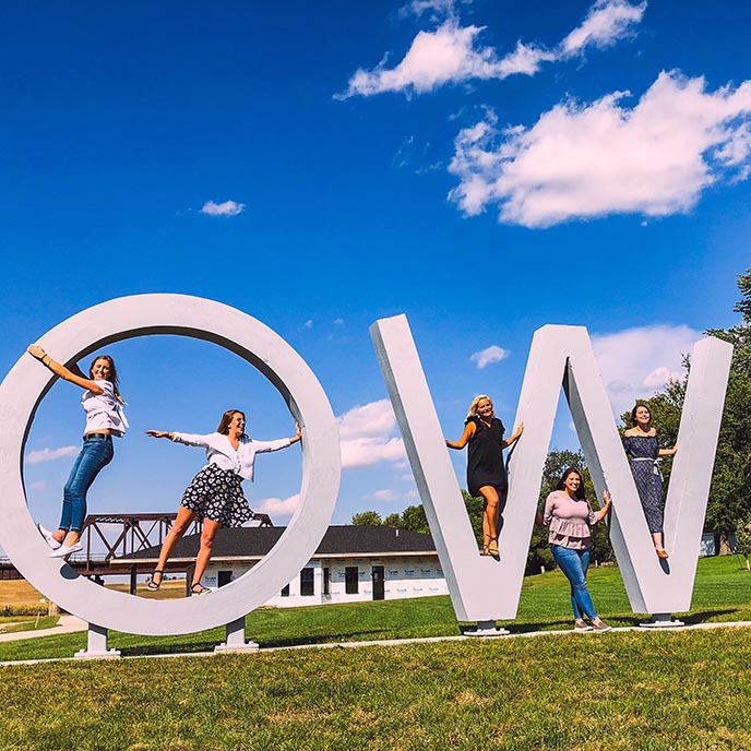 Student consultants pose with the Iowa letter sculpture in Manning.