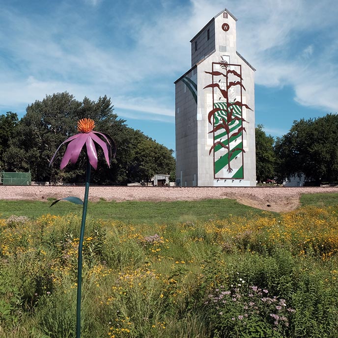 A grain elevator adorned with a 65-foot-tall metal corn stalk with LEDs, located in Woodbine, Iowa.