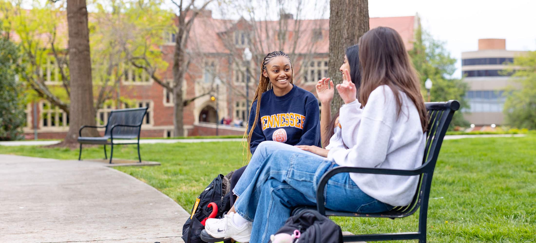 Three femal engineering students sitting in the courtyard in front of Ayres Hall on the UT campus.