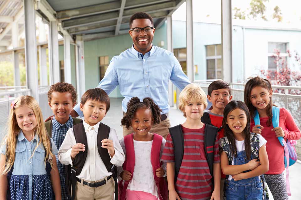 young black male teacher standing with students