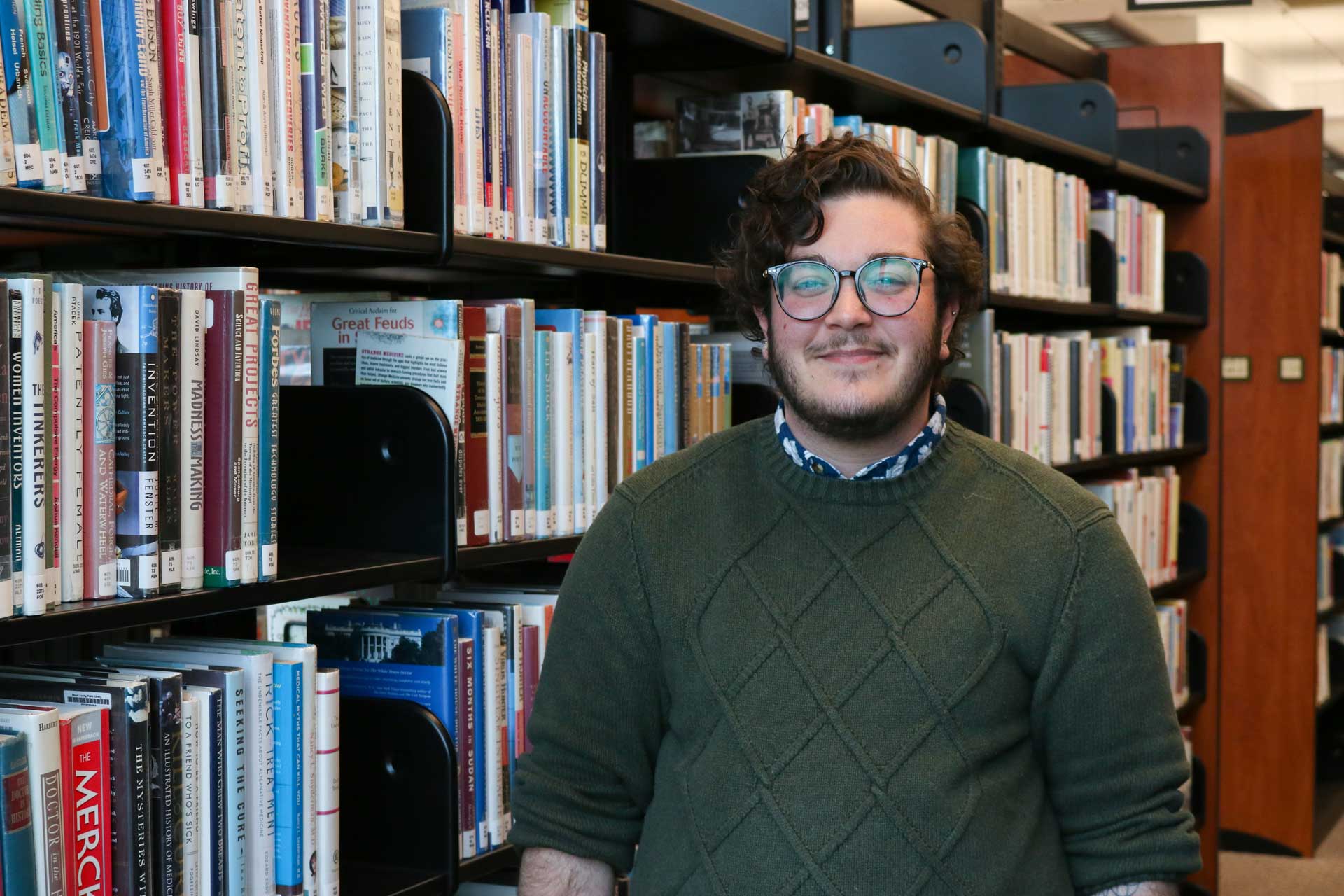 man standing in library stacks