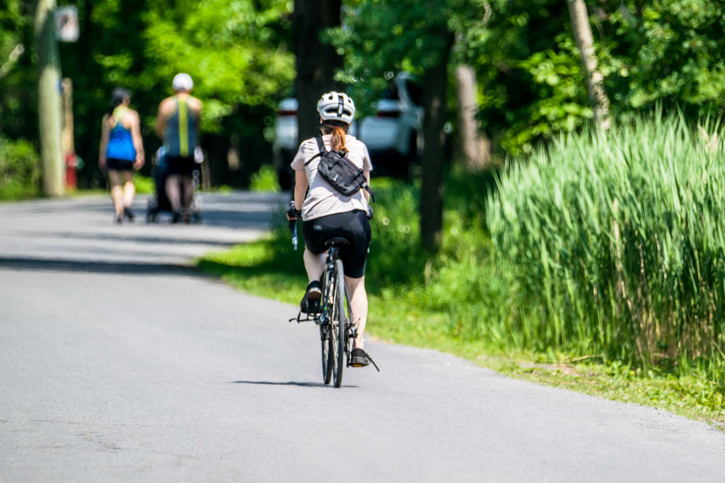 family walking alongside cyclist on trail