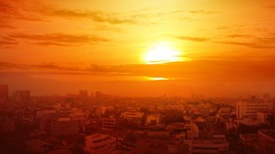 Heatwave on the city with the glowing sun background