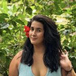 Person smiling with flower in hair