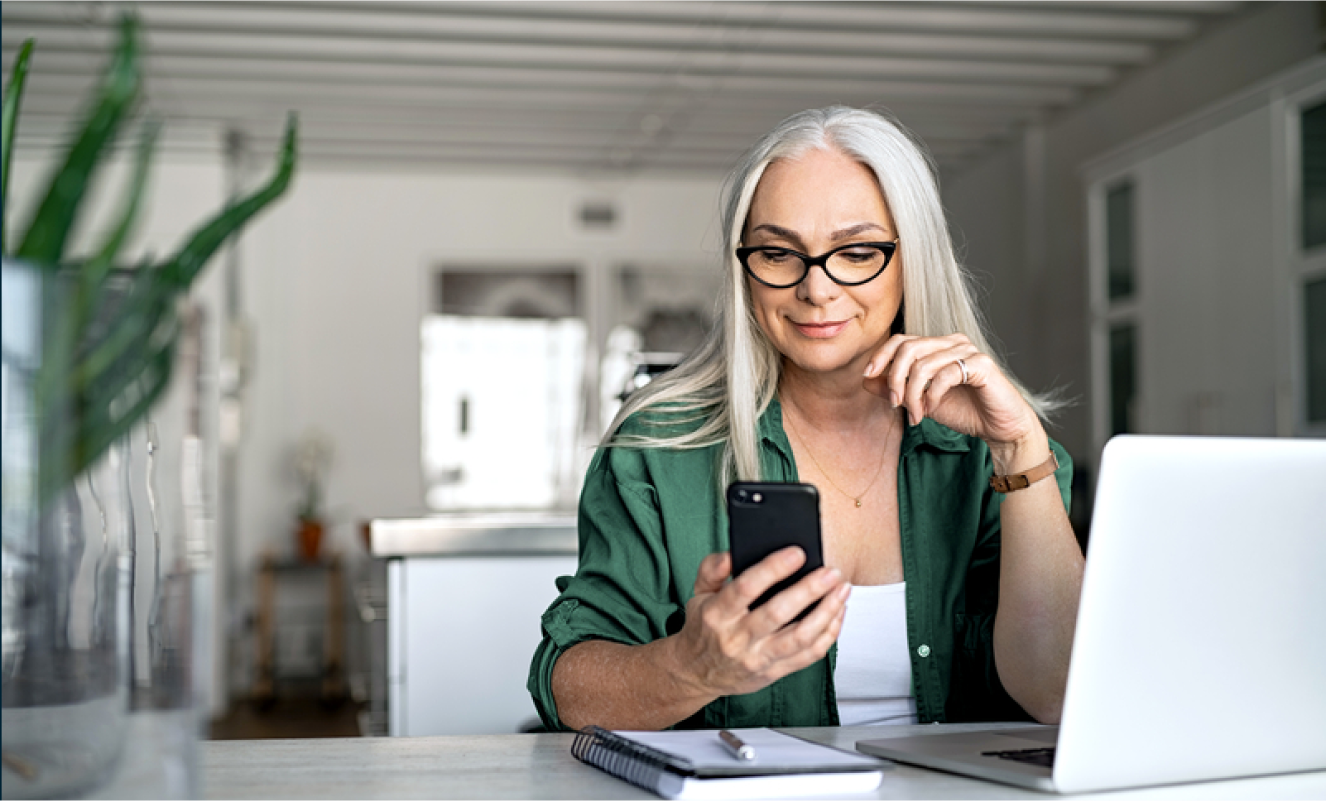 Woman looking at her ADT app on her phone in her home