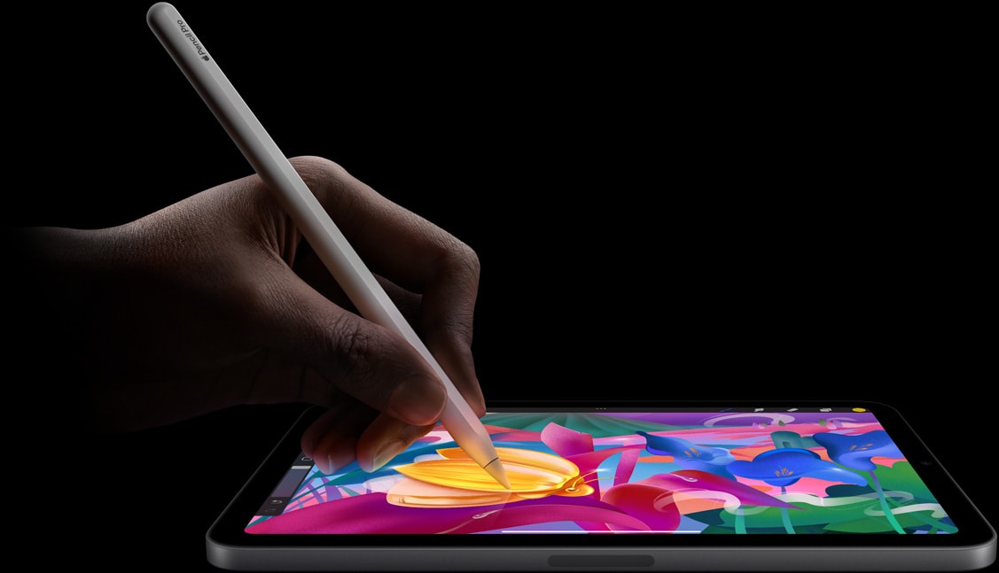 A user’s hand holding Apple Pencil Pro creating colourful artwork on iPad mini.