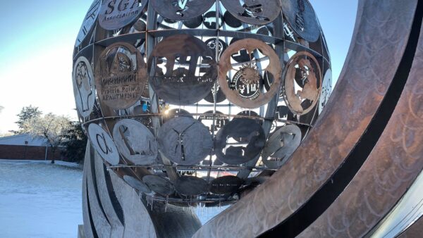 a sculpture of a sphere with persony different symbols