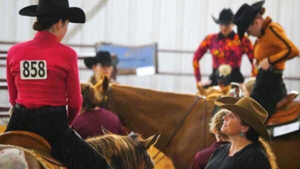 a group of people in western hats riding horses