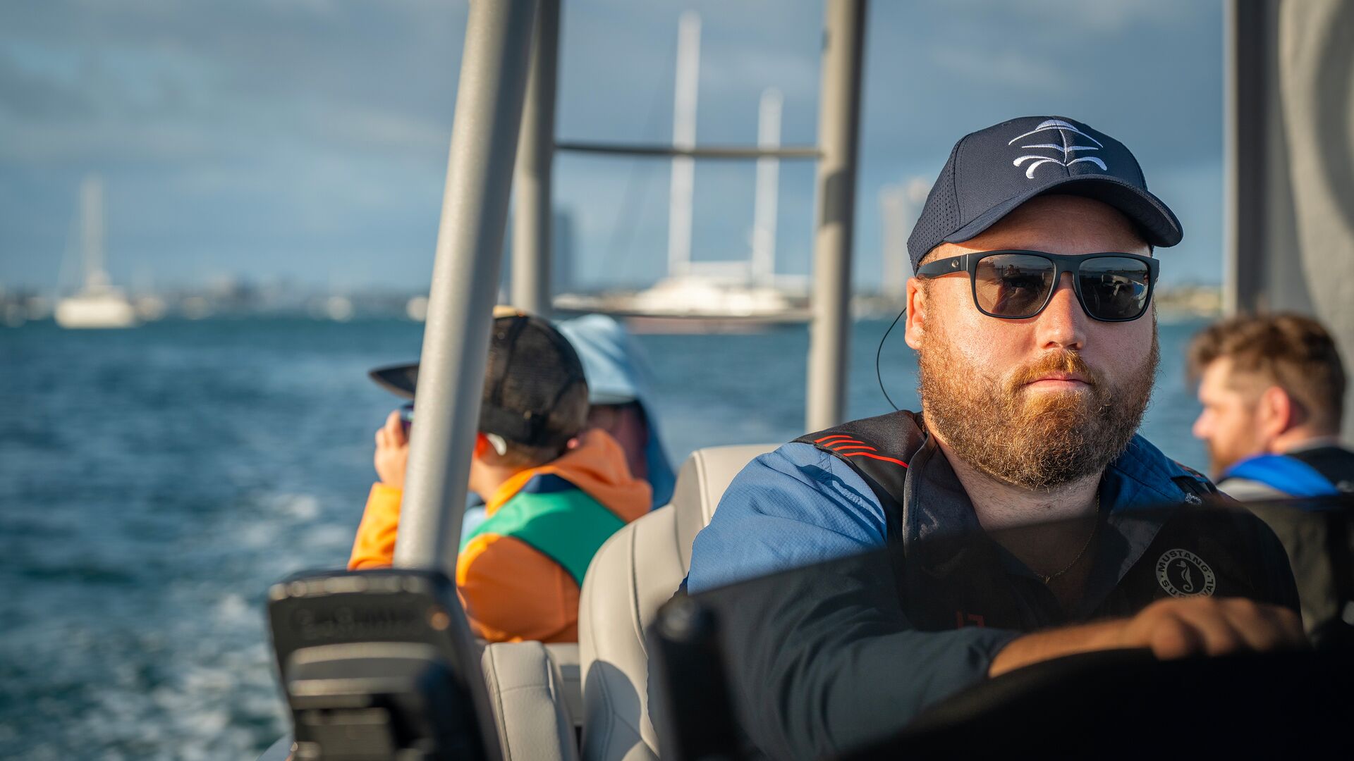 A man drives a boat with passengers behind him, how long do boating licenses last concept. 