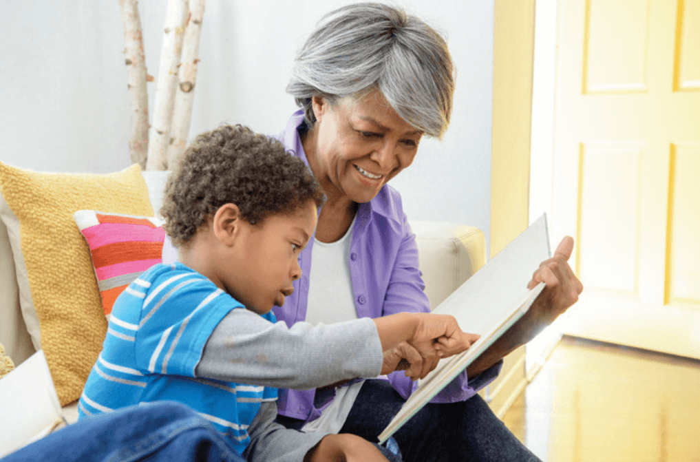 Grandmother reading with child at home.