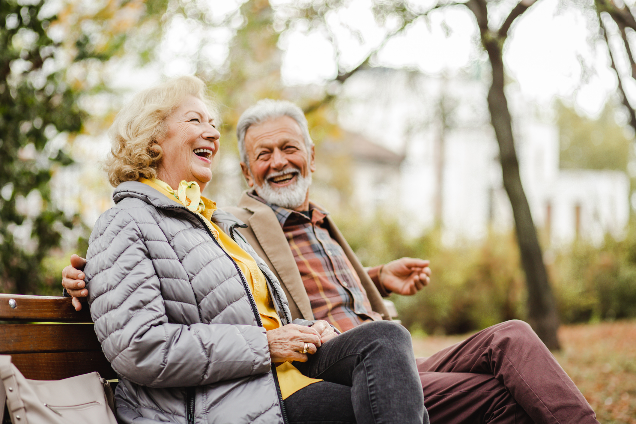 Happy senior couple sitting on the bench in park.