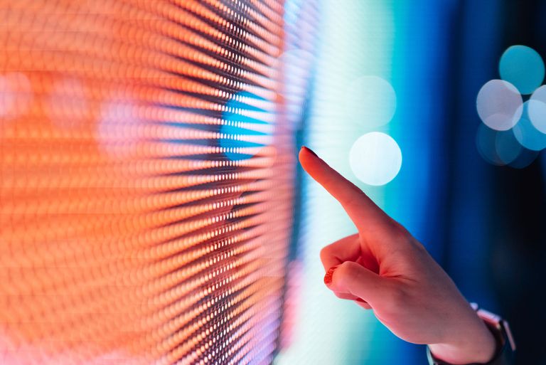 Photo of hand touching an LED screen with data