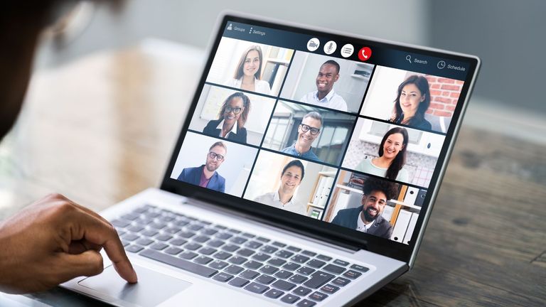 Photo from behind of a student in a virtual meeting on a laptop with other team members