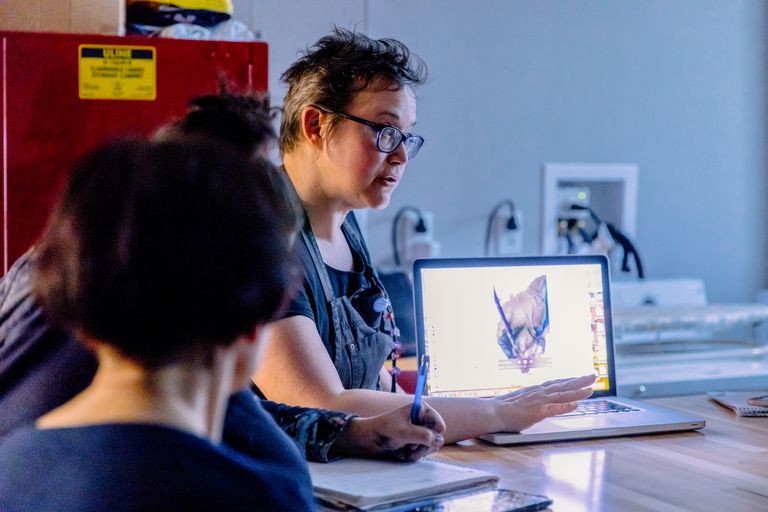 Teacher teaching students with laptop