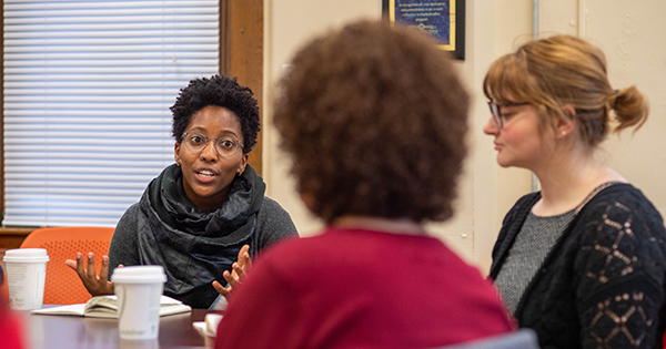 Taylor Cain (GRS’20), director of the Housing Innovation Lab, meets members of the Jamaica Plain Neighborhood Development Corp. Housing Innovation Lab intern Rebecca Christner pictured at right.