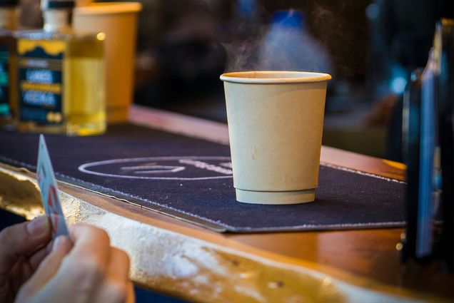 Photo: A person buying a cup of coffee with a credit card