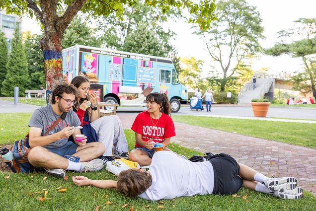 Photo: A picture of students lounging on the grass in front of food trucks