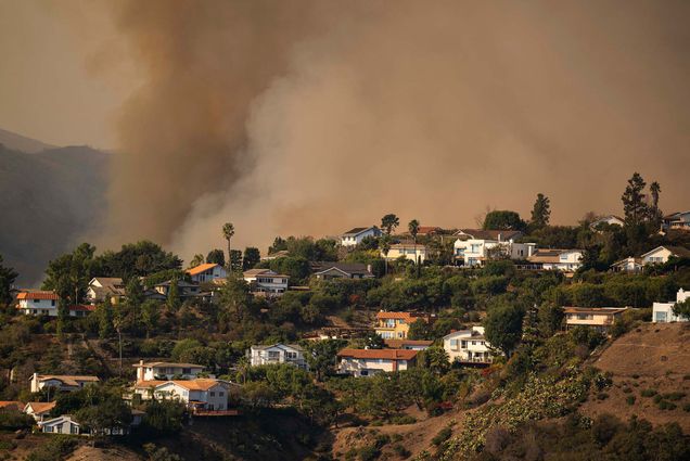 Photo: A hill with many houses on it being covered by smoke from the LA wildfires