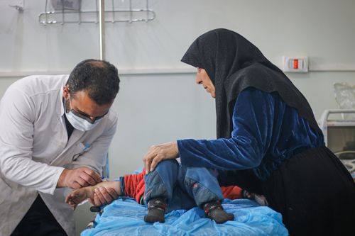 Doctor Treating Boy At Hospital With Mother