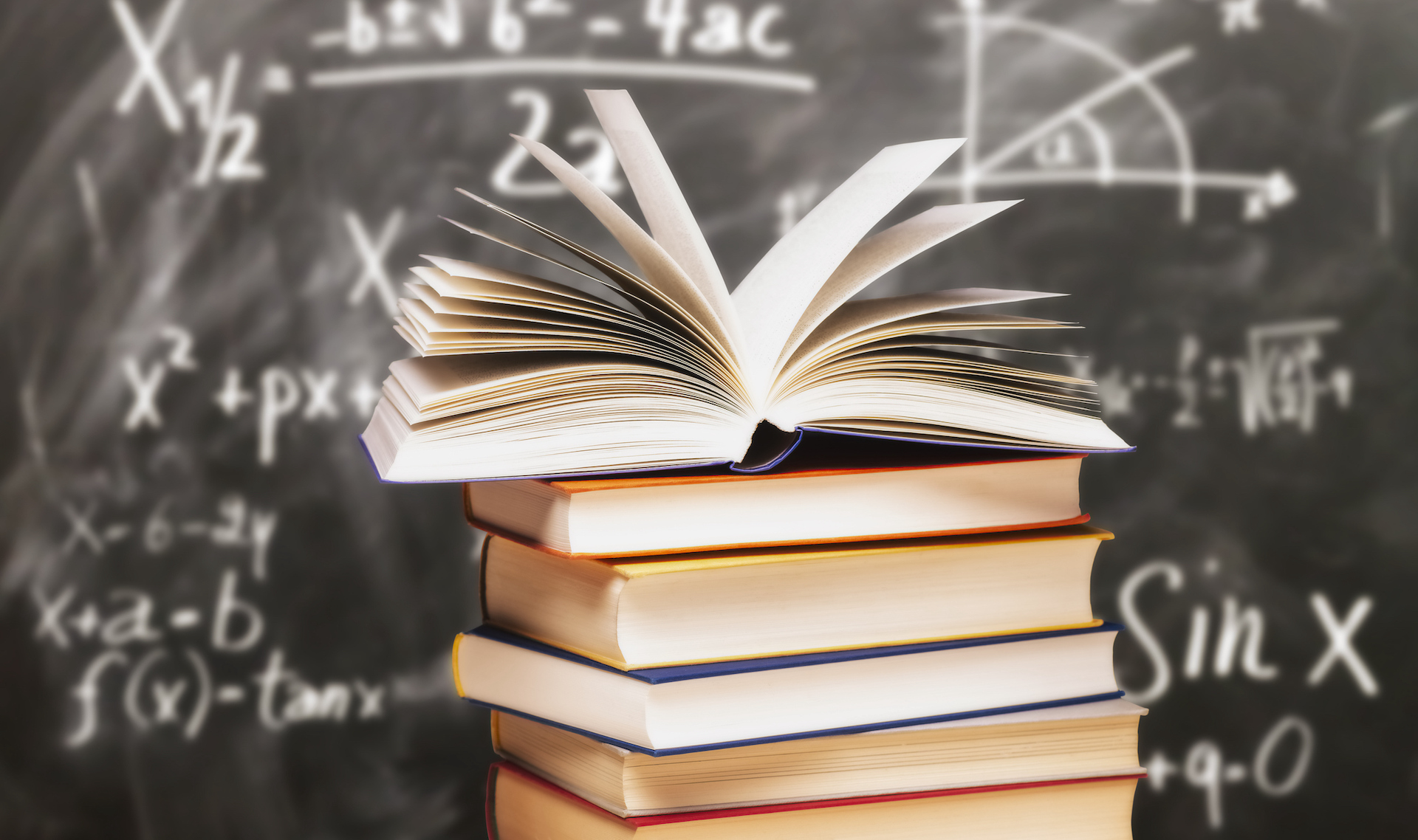 books in front of chalkboard with math equations