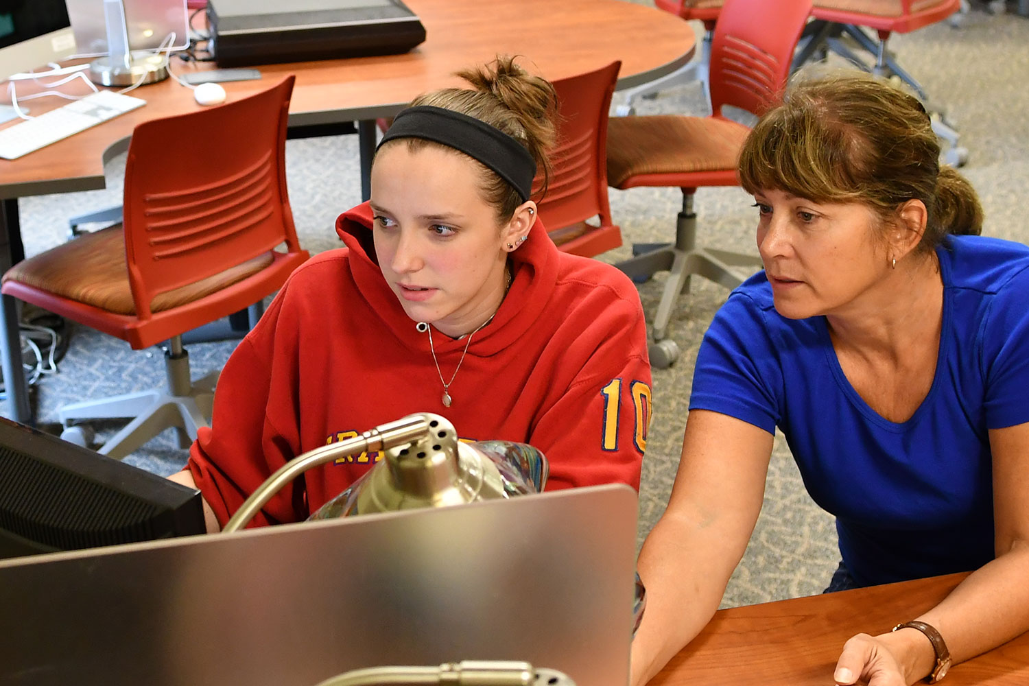 Female student at computer working with female tutor in the Library