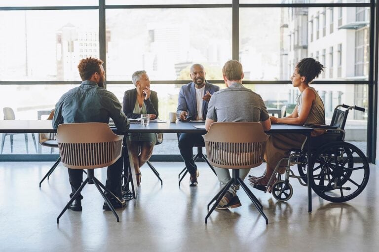 A group of people sitting around a table in a conference room.