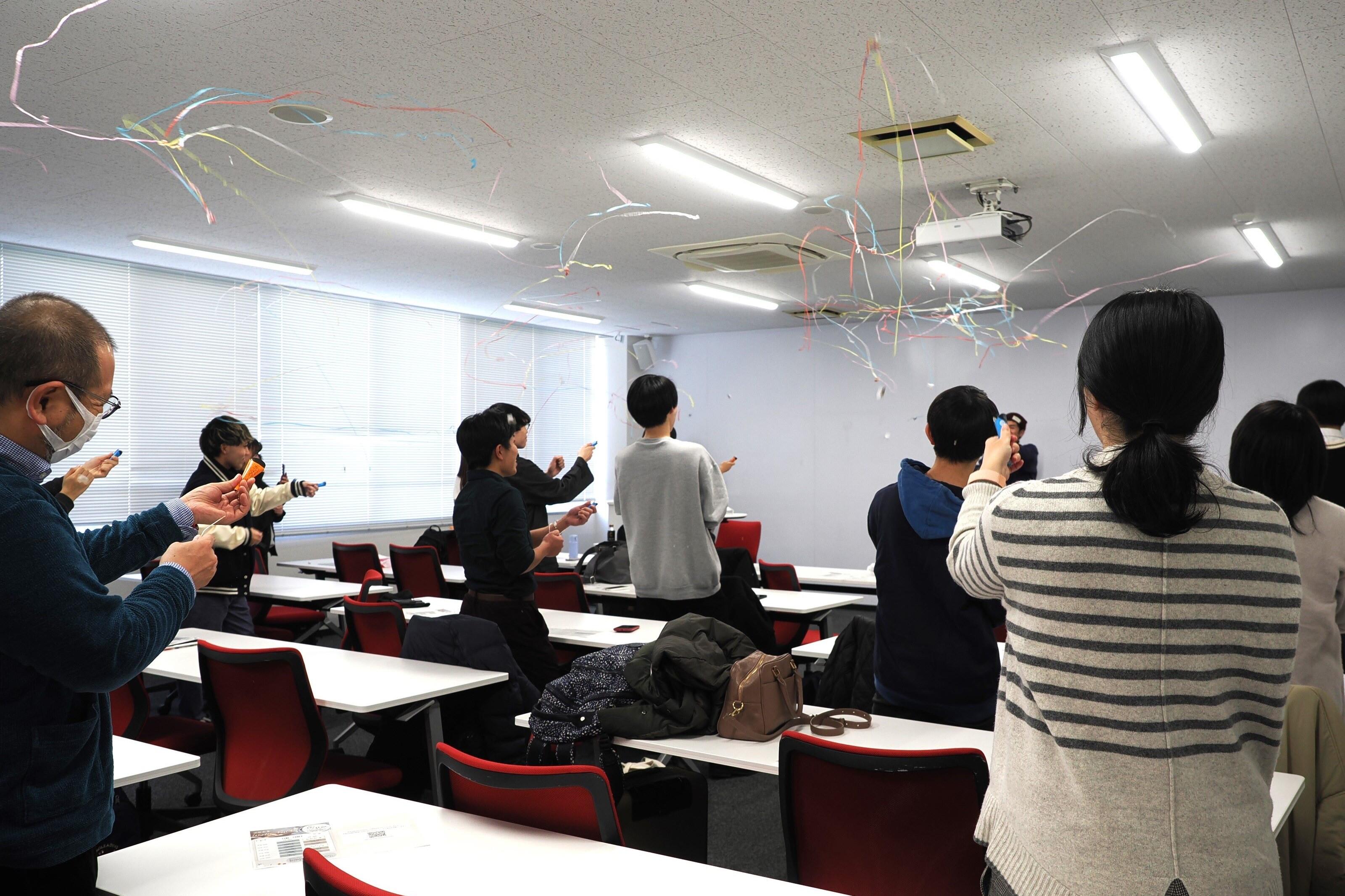 イベントの開会をクラッカーで祝う参加者たち