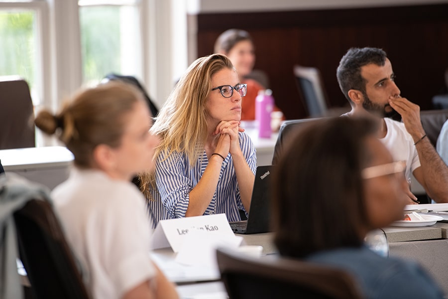 A student in a classroom listens intently to a speaker